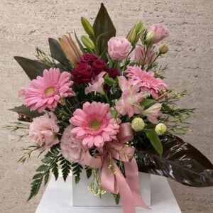 Pink gerbera box arrangement with roses, lilies and ribbon
